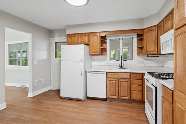 a kitchen with granite countertop a refrigerator stove top oven and sink