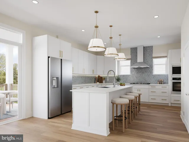 a kitchen with stainless steel appliances kitchen island granite countertop a dining table chairs sink and cabinets