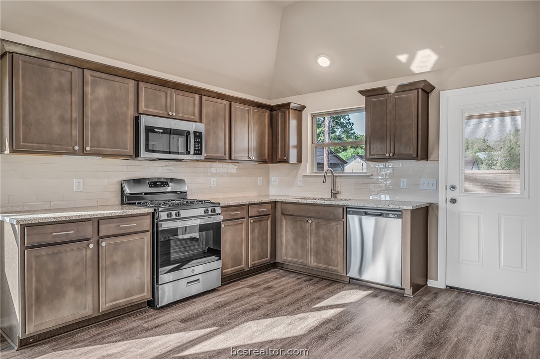 2766 Messenger Way Bryan, TX 77803 - Photo 5 of 12 a kitchen with stainless steel appliances granite countertop a stove a sink and a microwave