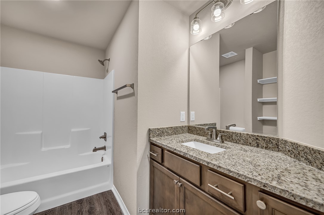 2766 Messenger Way Bryan, TX 77803 - Photo 8 of 12 a bathroom with a granite countertop sink mirror toilet and bathtub