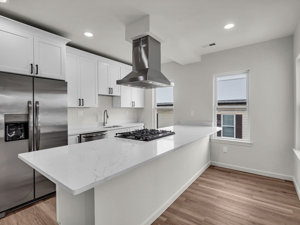 12 Alpine Street, Unit 3 Worcester, MA 01610 - Photo 1 of 1 a kitchen with stainless steel appliances a sink a stove a refrigerator cabinets and wooden floor