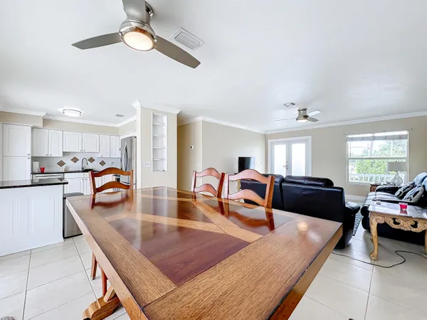 a living room with furniture a table and kitchen view
