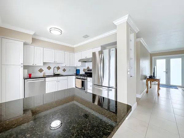 a kitchen with granite countertop a refrigerator and a sink