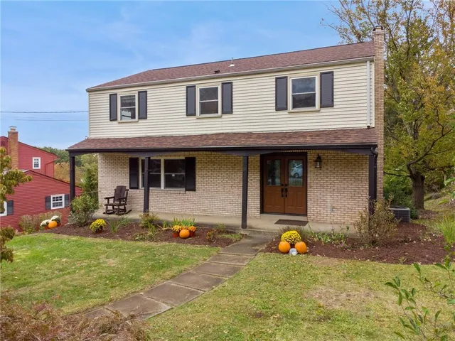 a front view of a house with swimming pool and porch