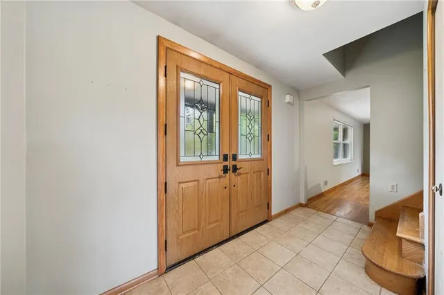 a view of a hallway with wooden floor and a bathroom