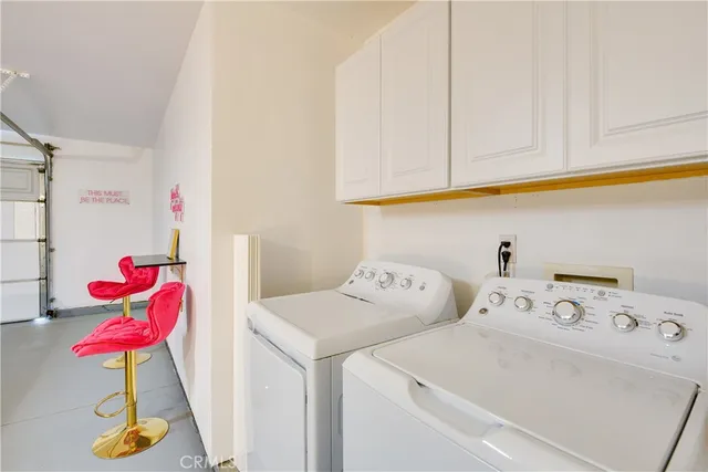 a utility room with dryer and cabinets