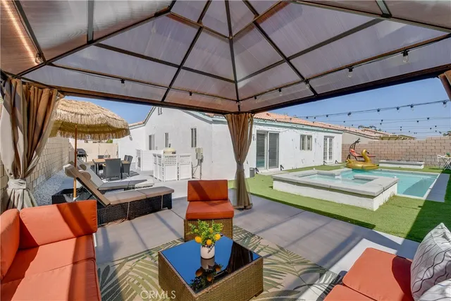 an outdoor sitting area with furniture and umbrella