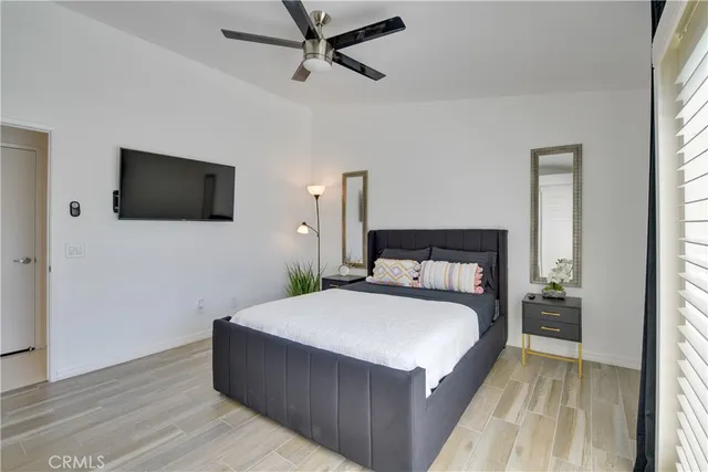 a spacious bedroom with a bed and a flat screen tv