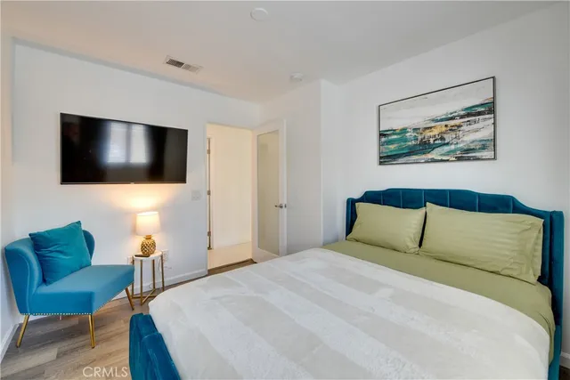 a bedroom with a large bed and a flat screen tv