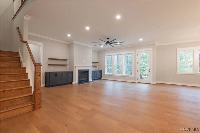 a view of an empty room with window and wooden floor