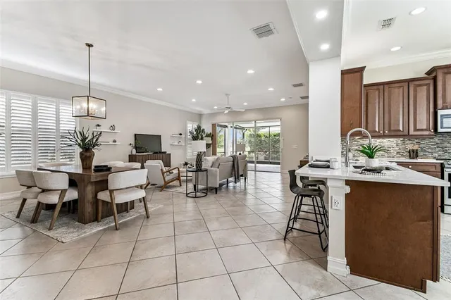 a kitchen with a dining table chairs and white cabinets
