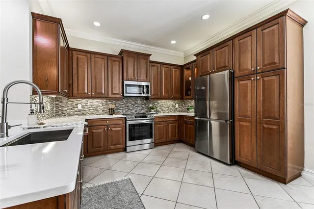 a kitchen with stainless steel appliances granite countertop a refrigerator sink and stove