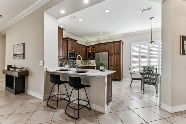 a kitchen with stainless steel appliances kitchen island granite countertop a sink and a refrigerator