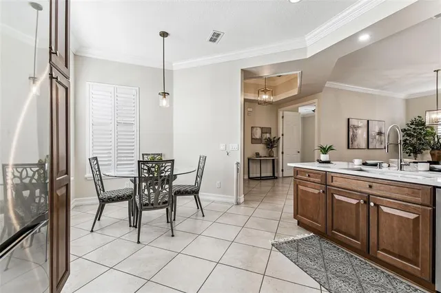 a large kitchen with kitchen island granite countertop a table and chairs in it