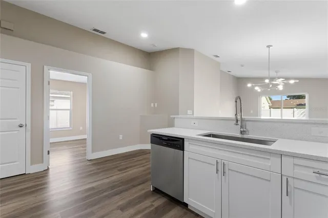 a kitchen with a sink cabinets and wooden floor