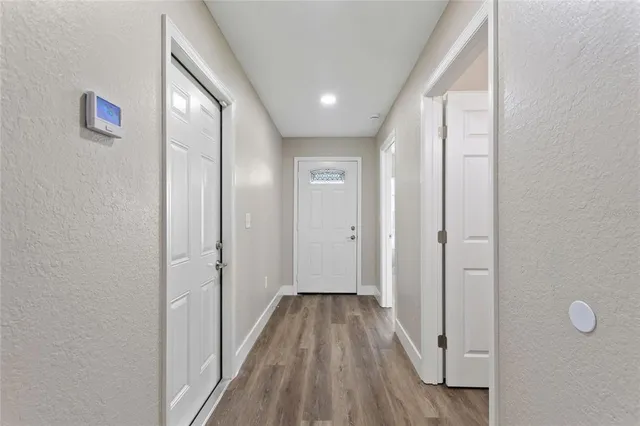 a view of a hallway with wooden floor and closet