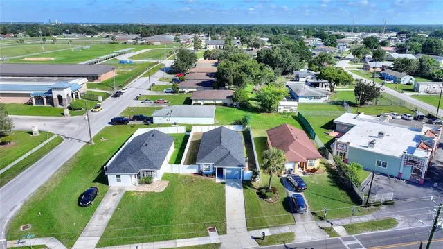 an aerial view of residential houses with outdoor space and parking
