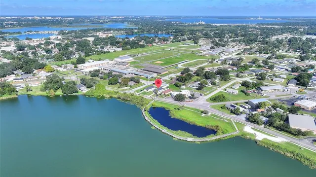 an aerial view of a house with a garden and lake view