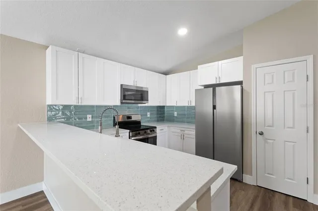 a kitchen with a refrigerator a microwave a sink and cabinets