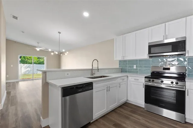 a kitchen with stainless steel appliances a sink a stove and microwave