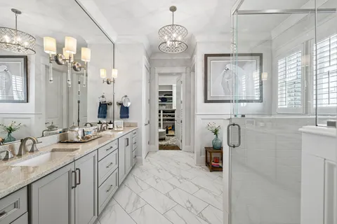 a bathroom with a double vanity sink a toilet a mirror and shower