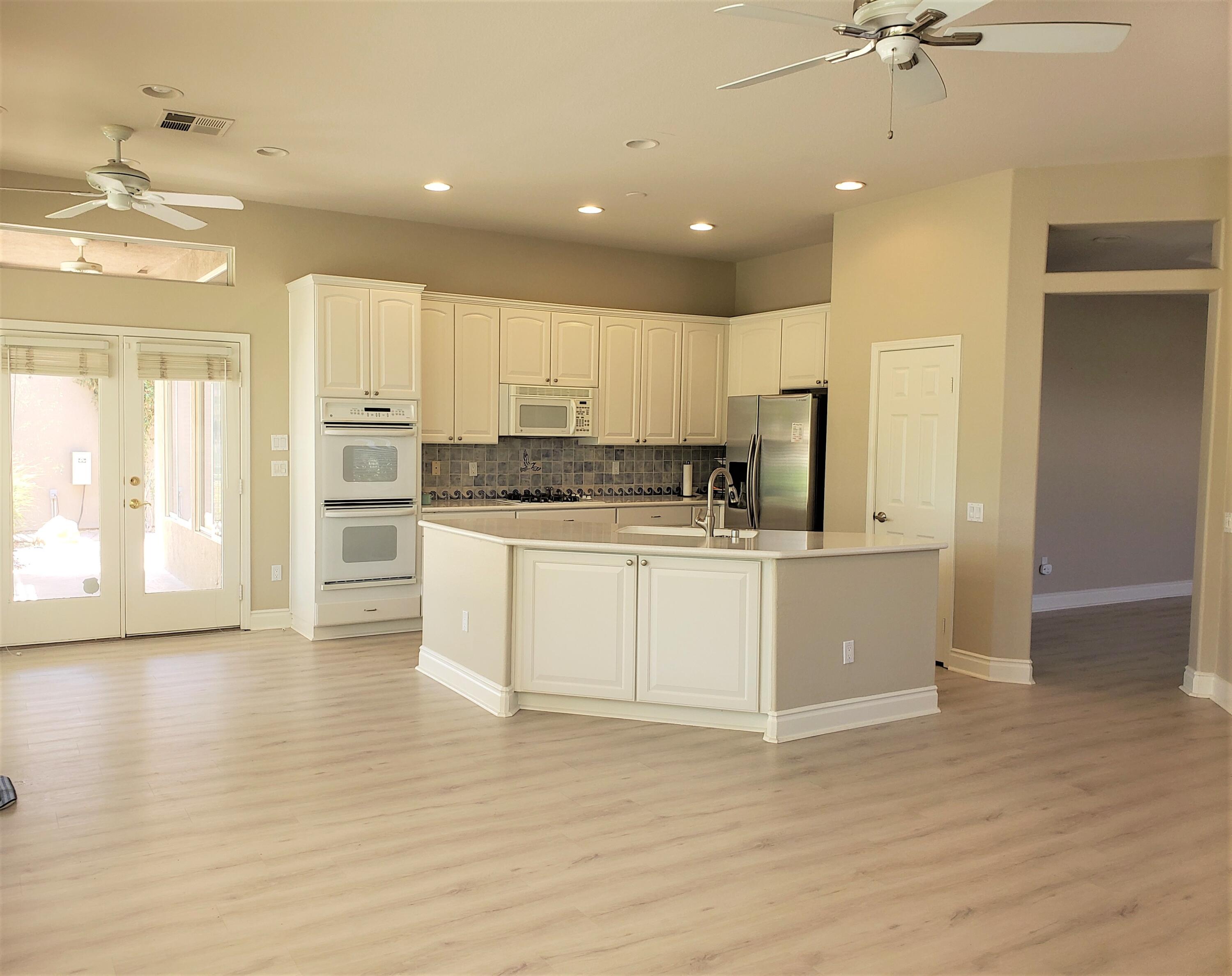 44017 Royal Troon Drive Indio, CA 92201 - Photo 11 of 33 a kitchen with wooden cabinets and white appliances