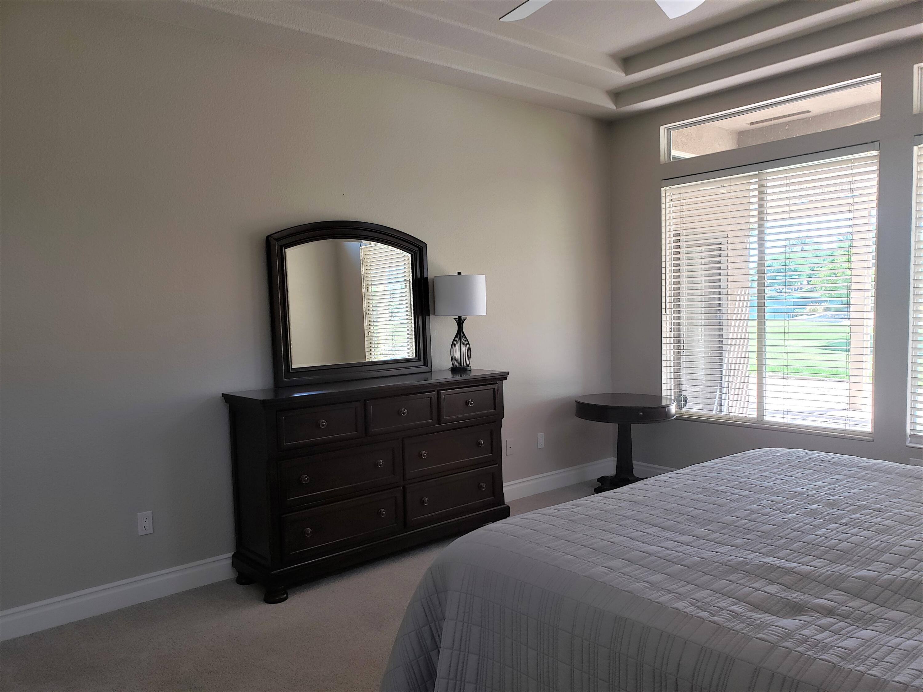 44017 Royal Troon Drive Indio, CA 92201 - Photo 18 of 33 a bedroom with a bed and a mirror on dresser