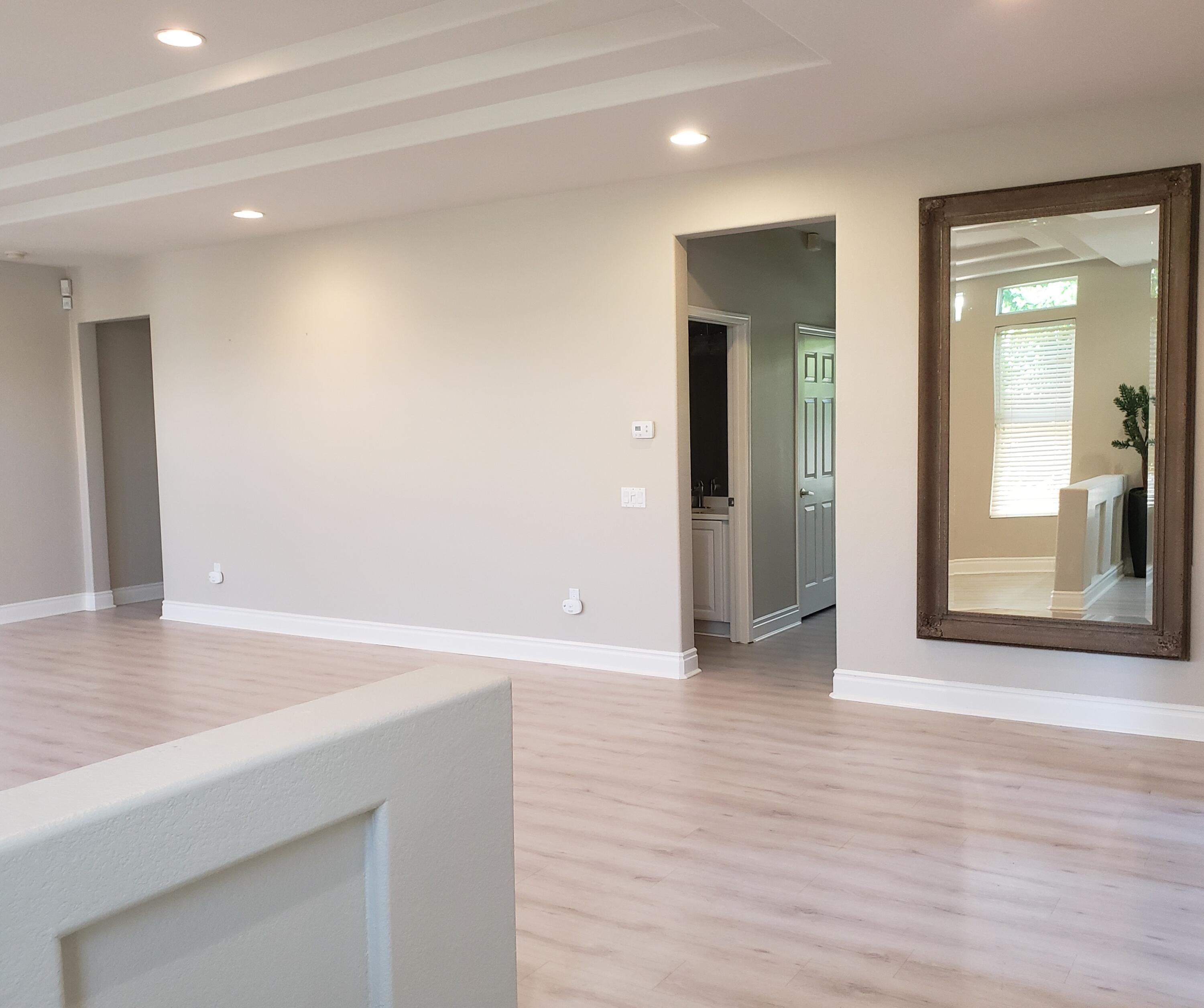 44017 Royal Troon Drive Indio, CA 92201 - Photo 7 of 33 an empty room with wooden floor and windows