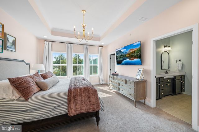 a bedroom with a large bed and a chandelier