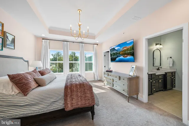 a bedroom with a large bed and a chandelier