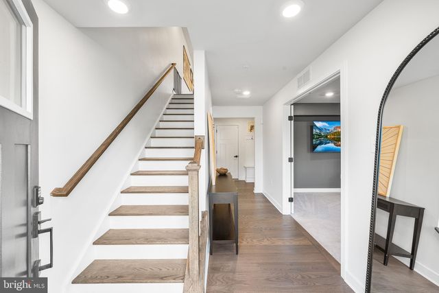 a view of an entryway with wooden floor and stairs