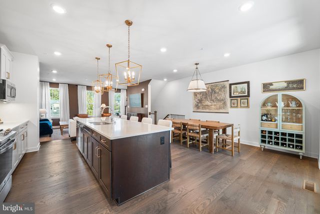 a large kitchen with lots of counter space a sink dining table and chairs