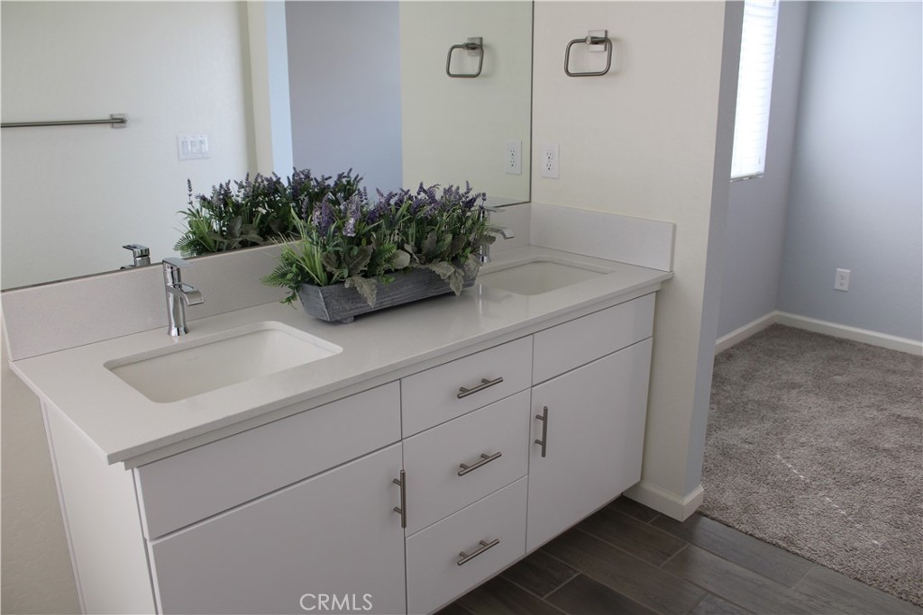 2060 North Walker Lane Clovis, CA 93619 - Photo 13 of 17 a bathroom with a sink a mirror and a potted plant