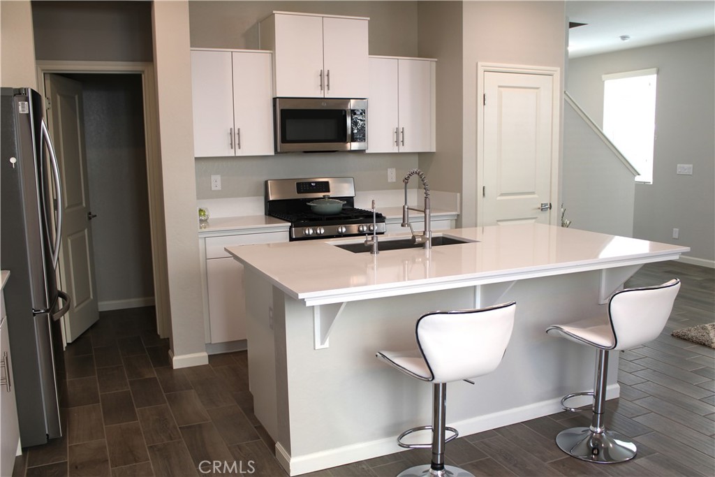 2060 North Walker Lane Clovis, CA 93619 - Photo 6 of 17 a kitchen with stainless steel appliances a stove a sink a microwave a refrigerator and cabinets