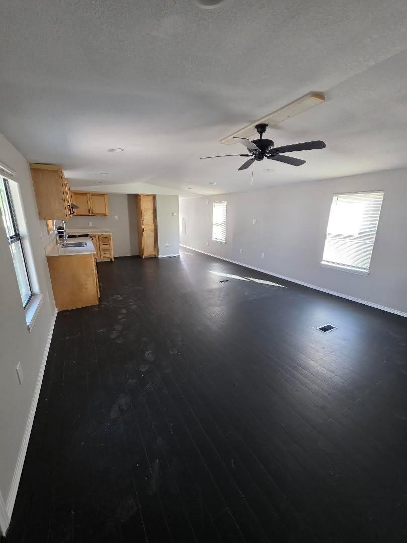 310 Paddock Street, Unit 4 Willis, TX 77378 - Photo 4 of 14 an empty room with windows and ceiling fan