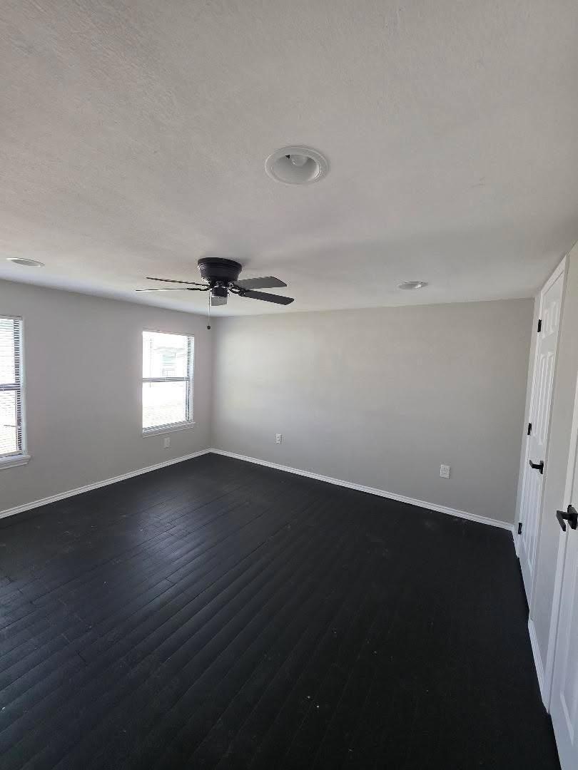 310 Paddock Street, Unit 4 Willis, TX 77378 - Photo 6 of 14 an empty room with wooden floor and windows