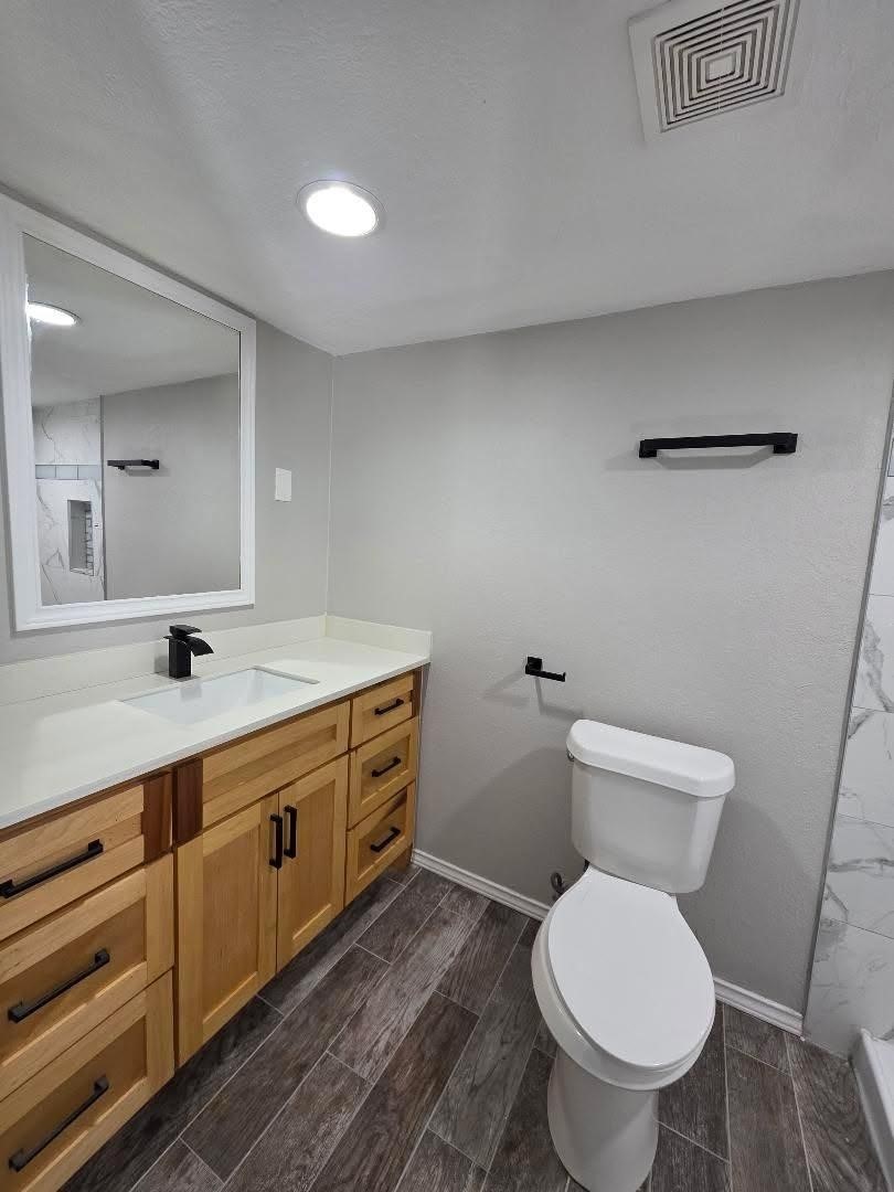 310 Paddock Street, Unit 4 Willis, TX 77378 - Photo 7 of 14 a bathroom with a toilet sink and mirror