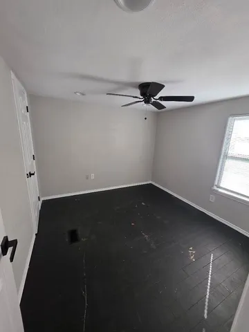 an empty room with wooden floor and cabinet