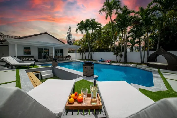 a view of a house with swimming pool and sitting area