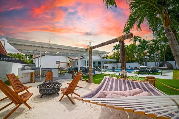 a view of swimming pool with lounge chair and dinning table under an umbrella