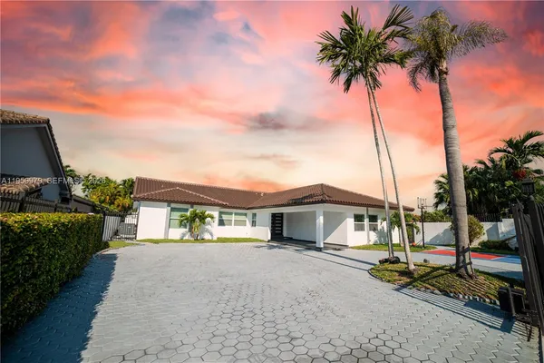 a front view of a house with a garden and balcony