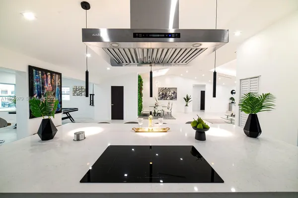 a kitchen with a sink a potted plant and a large mirror