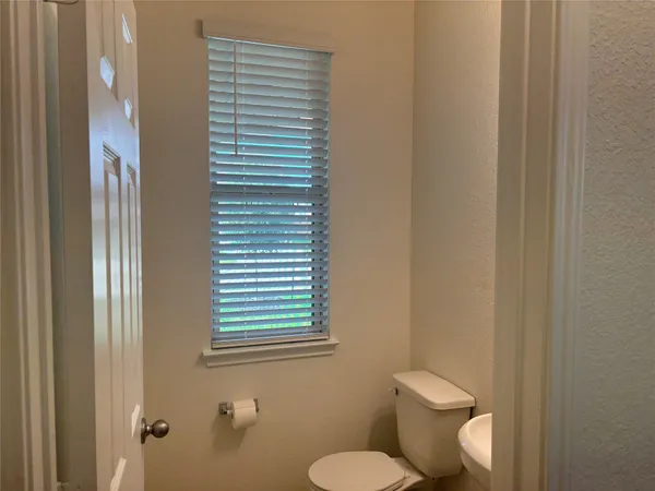 a white toilet sitting next to a window