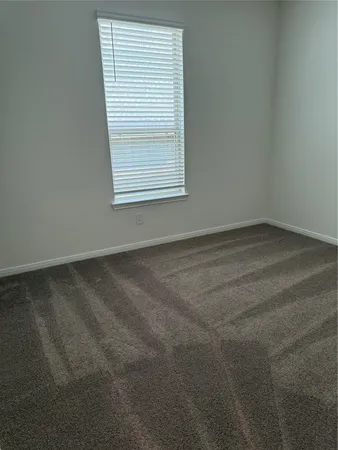 an empty room with windows and ceiling fan