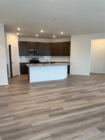 a view of kitchen with kitchen island stainless steel appliances refrigerator and stove