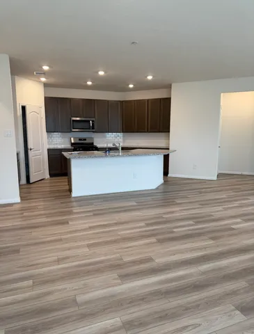 a view of kitchen with kitchen island stainless steel appliances refrigerator and stove