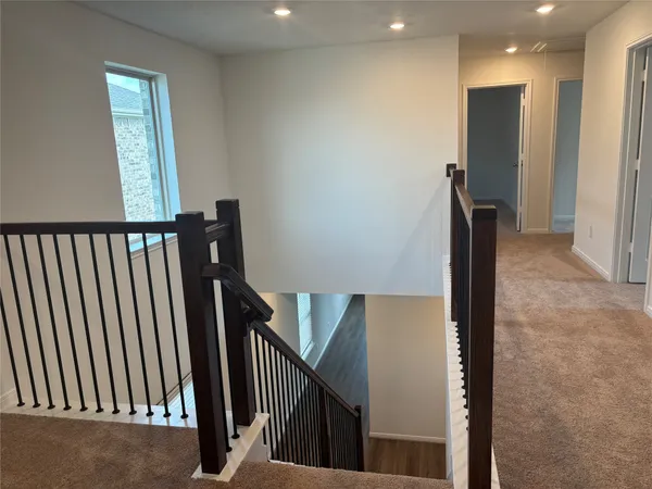 a view of a hallway with windows and stairs