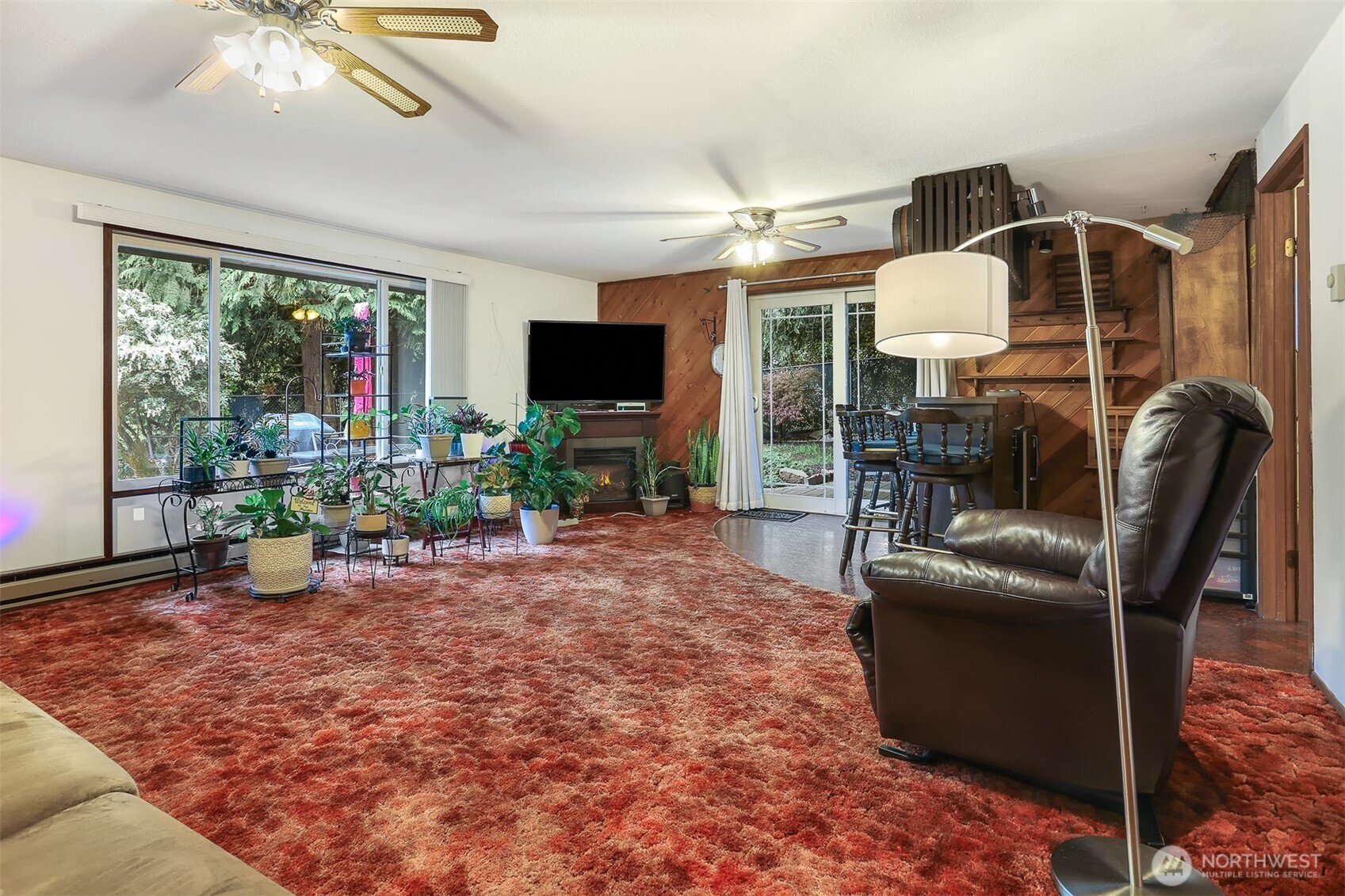11120 3rd Place Southeast Everett, WA 98208 - Photo 17 of 35 a living room with furniture a flat screen tv and a floor to ceiling window