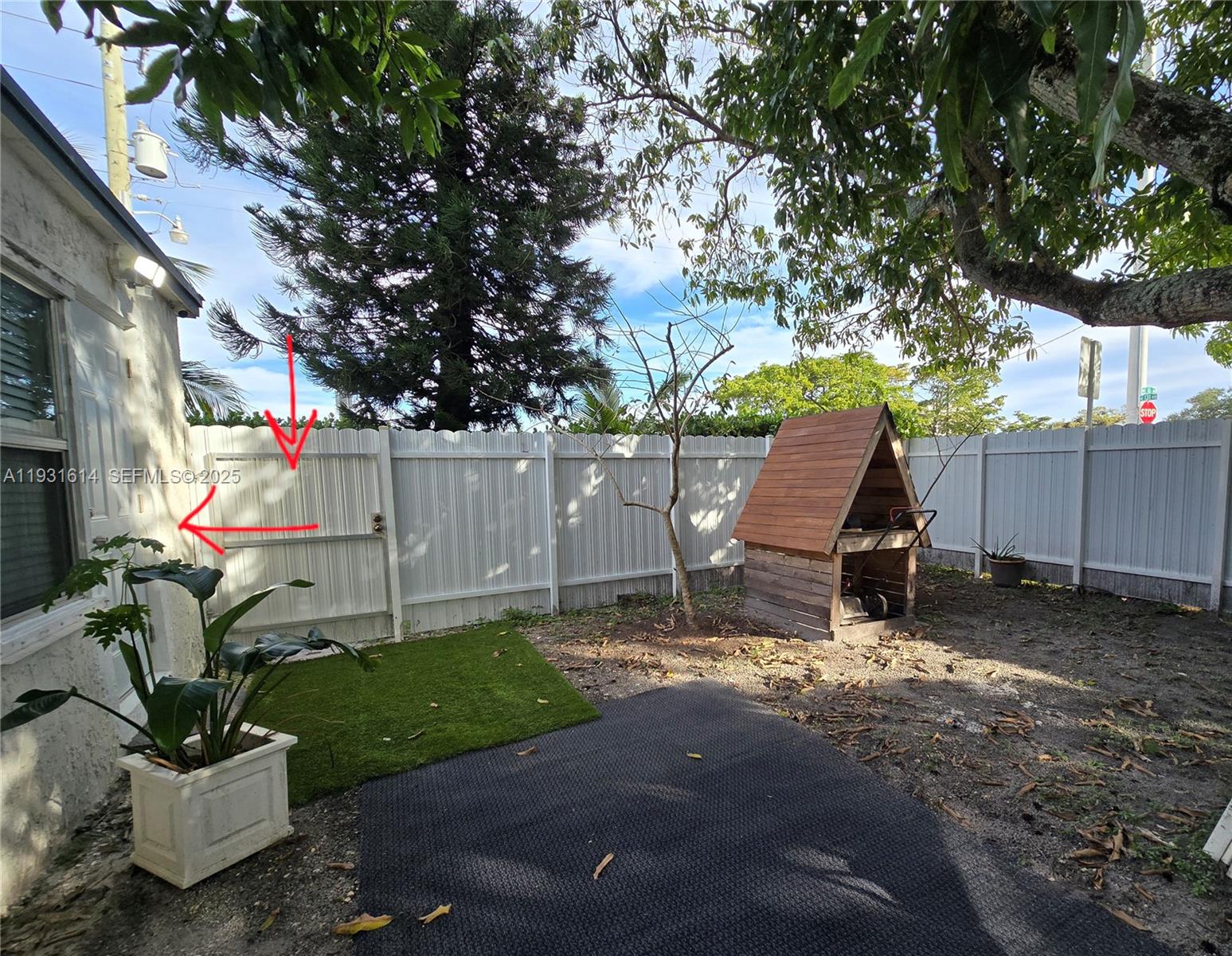 13340 Northeast 16th Avenue North Miami, FL 33161 - Photo 15 of 18 a view of backyard with wooden fence and a large tree