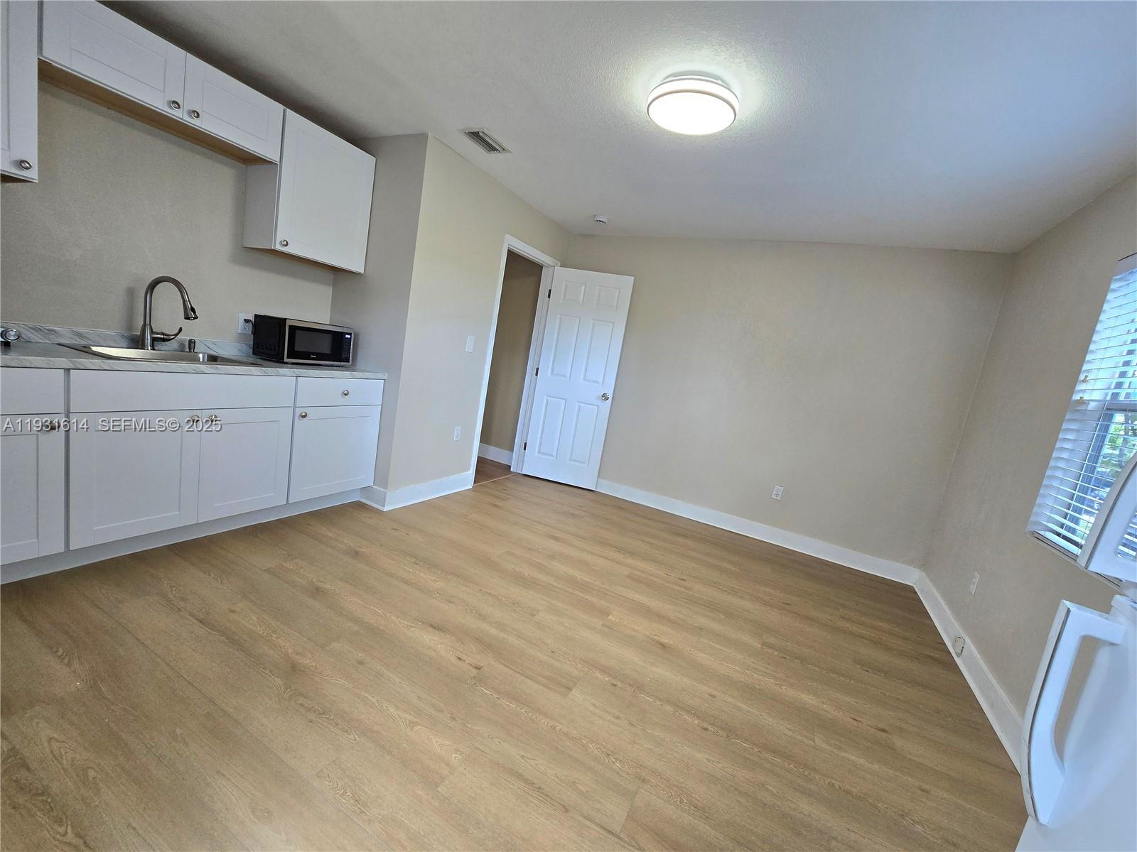 13340 Northeast 16th Avenue North Miami, FL 33161 - Photo 2 of 18 a view of a kitchen with wooden floor and electronic appliances
